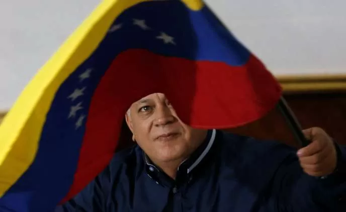 Un homme agite un drapeau tricolore bleu, jaune et rouge avec des étoiles blanches sur fond clair