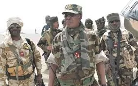 Un groupe de militaires en tenue de camouflage marchant dans un environnement désertique sous un ciel clair