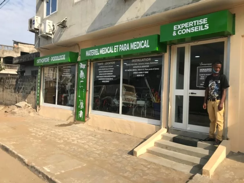 Façade d un magasin avec enseignes vertes pour matériel médical et para médical un homme debout près de l entrée