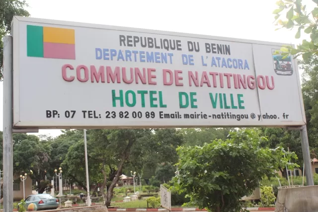 Panneau indiquant l'hôtel de ville de la commune avec le drapeau du pays et des arbres en arrière-plan