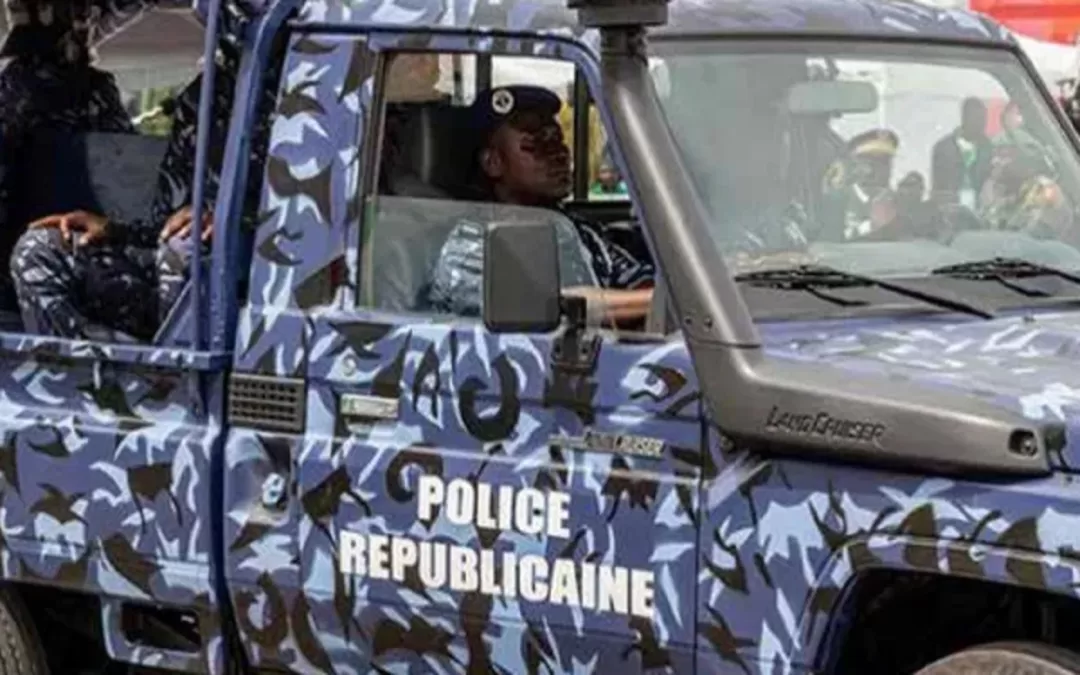 Un véhicule militaire camouflé marqué Police Républicaine avec des agents en uniforme à l’intérieur lors d’une opération.