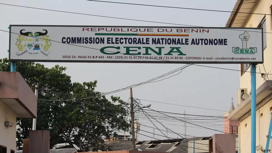 Bannière suspendue entre deux bâtiments avec inscription sur la commission électorale nationale autonome et logos sur fond urbain et ciel gris