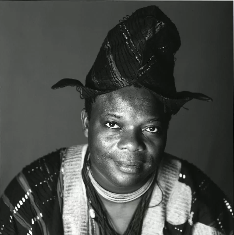 Portrait en noir et blanc d’un homme portant un bonnet traditionnel et une tenue à motifs ethniques