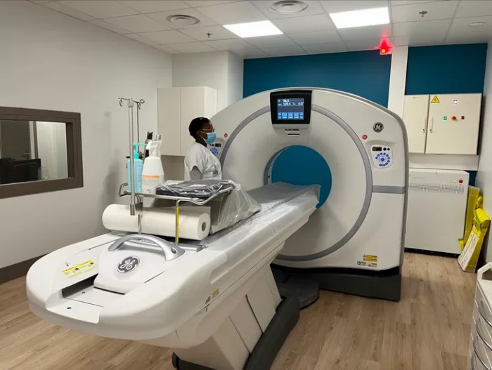 Scanner médical installé dans une salle avec un professionnel de santé portant un masque à proximité