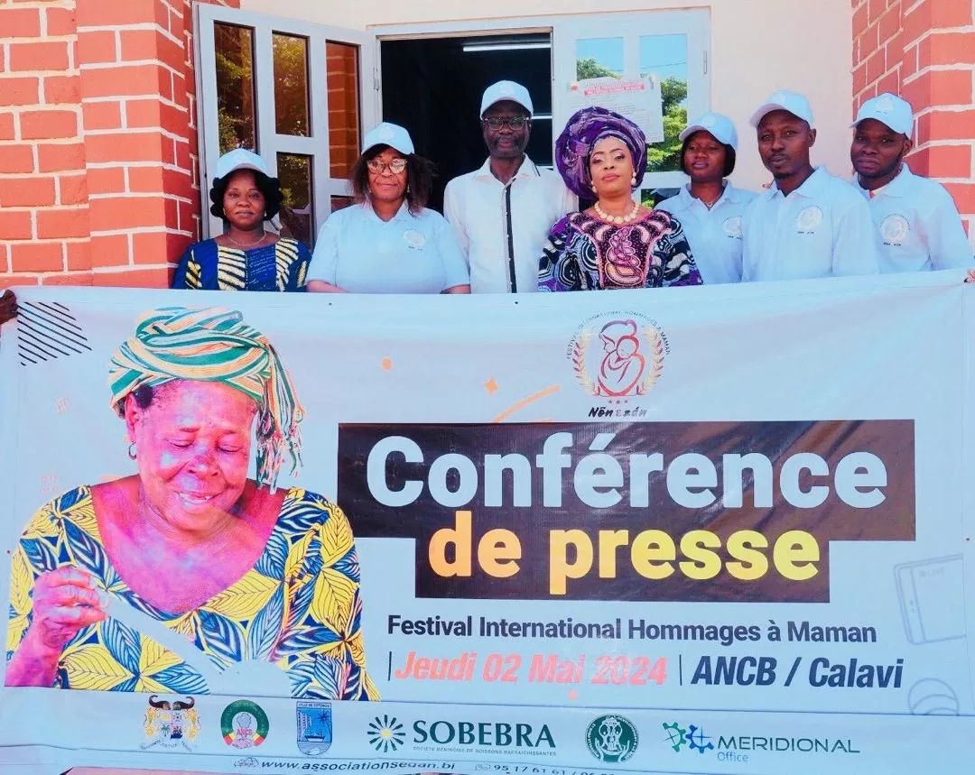 Sept personnes posent derrière une banderole annonçant une conférence de presse pour un festival international hommage à maman