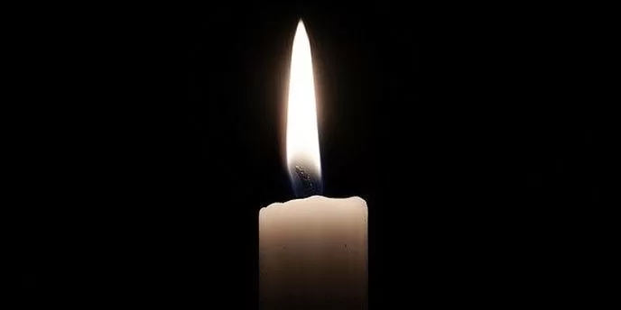 Bougie allumée sur fond noir avec une flamme brillante au centre de l image