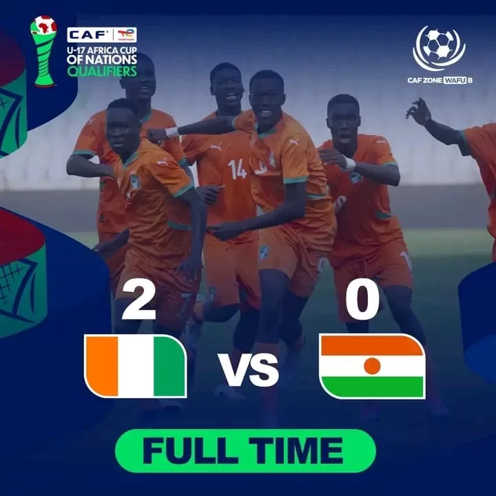 Joueurs de football adolescents en maillots orange célébrant un but sur le terrain avec score 2-0 affiché à l’écran