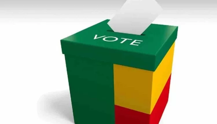 Urne tricolore verte jaune rouge avec une feuille insérée au-dessus et le mot VOTE inscrit dessus