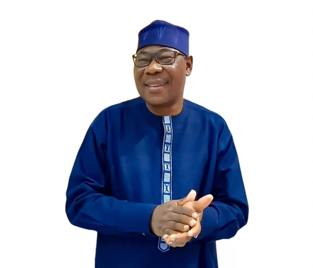 Homme souriant en tenue traditionnelle bleue avec un chapeau assorti et des lunettes sur fond blanc