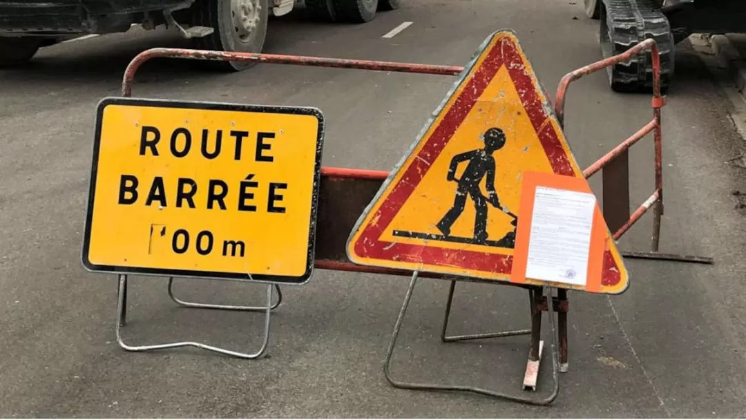 Deux panneaux de signalisation indiquant que la route est barrée et des travaux en cours