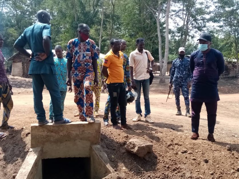 Un groupe d hommes debout autour d un ouvrage d assainissement sur un chantier en milieu rural boisé