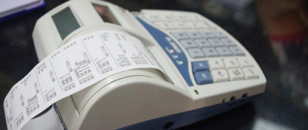Machine à calculer avec un rouleau de tickets imprimés posé sur une surface sombre
