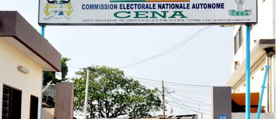Entrée d’un bâtiment avec une grande enseigne portant le nom et les coordonnées d’une commission électorale nationale autonome