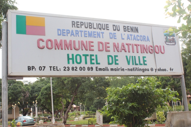 Panneau indiquant l'hôtel de ville de la commune avec le drapeau du pays et des arbres en arrière-plan