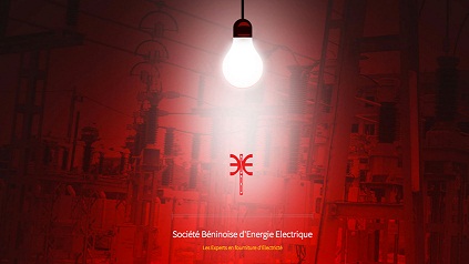 Ampoule allumée suspendue dans un espace rouge avec le logo et le nom de la Société Béninoise d’Energie Electrique visible en bas
