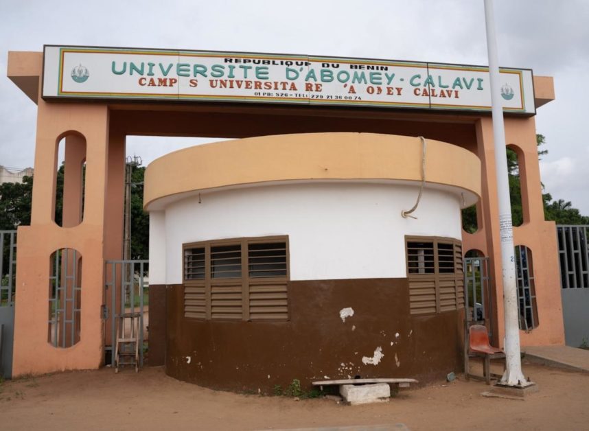 Entrée principale d’un campus universitaire avec un guichet fermé et un panneau d’identification au-dessus