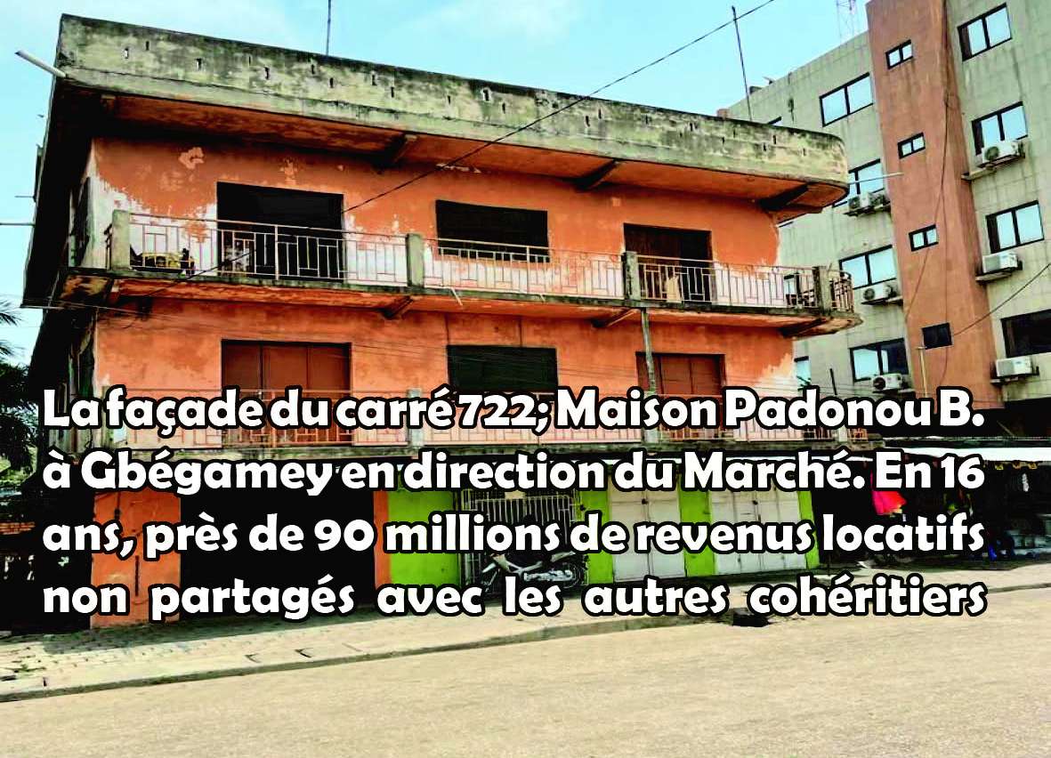 Façade d’un bâtiment ancien à deux étages avec balcon rouillé, situé en bordure de rue et entouré de bâtiments modernes plus hauts