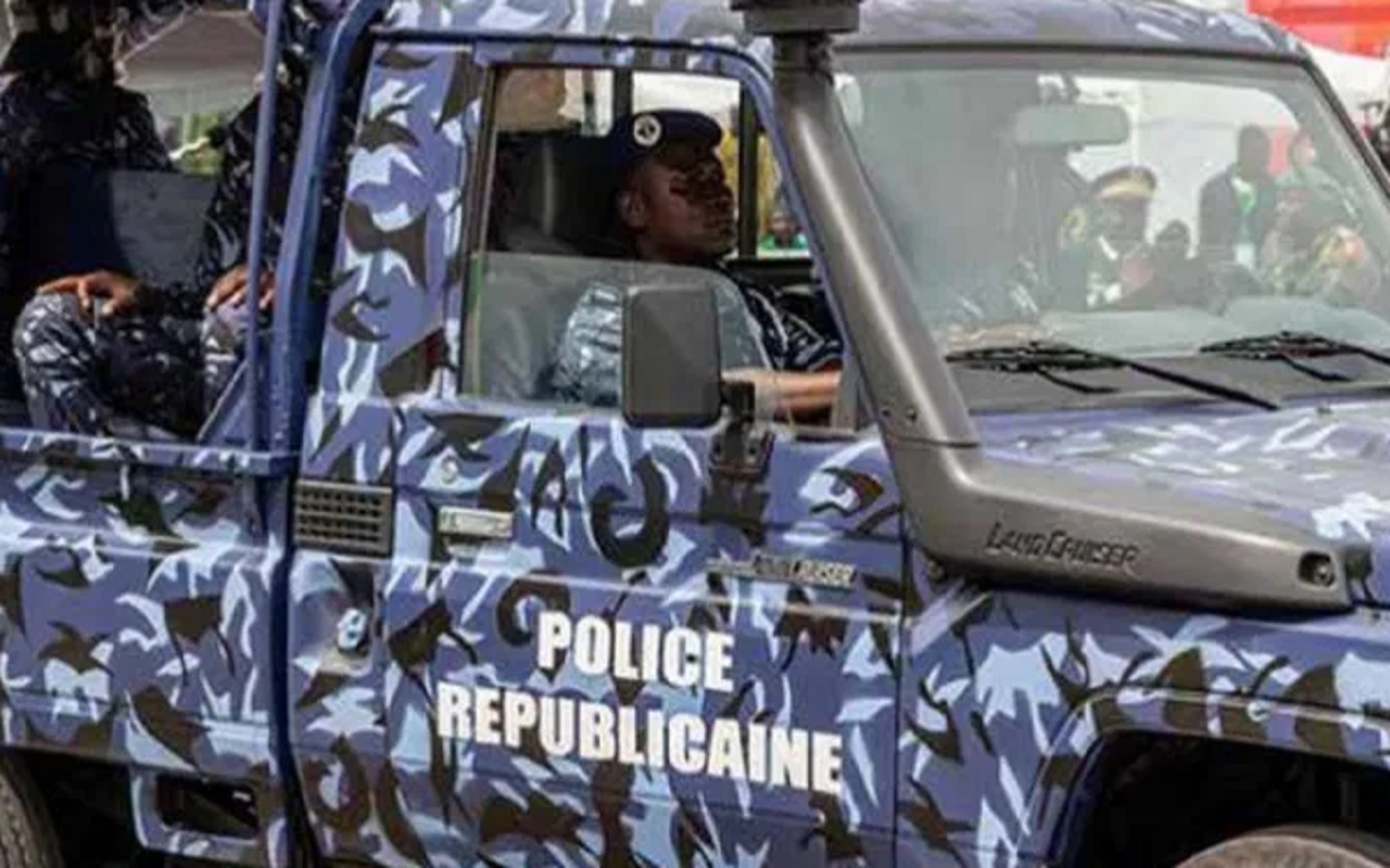 Un véhicule militaire camouflé marqué Police Républicaine avec des agents en uniforme à l’intérieur lors d’une opération.