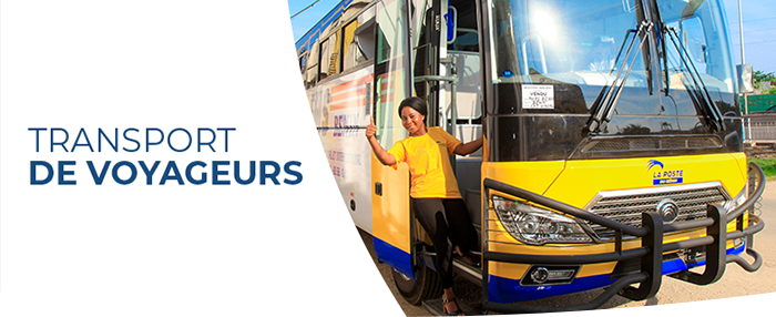 Une femme en tenue jaune sort d un grand bus jaune stationné sous un ciel bleu lumineux