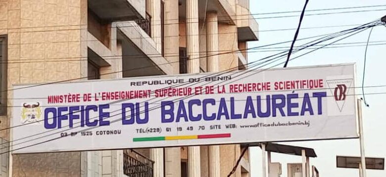 Bannière officielle de l'Office du Baccalauréat suspendue entre deux bâtiments avec des câbles électriques visibles