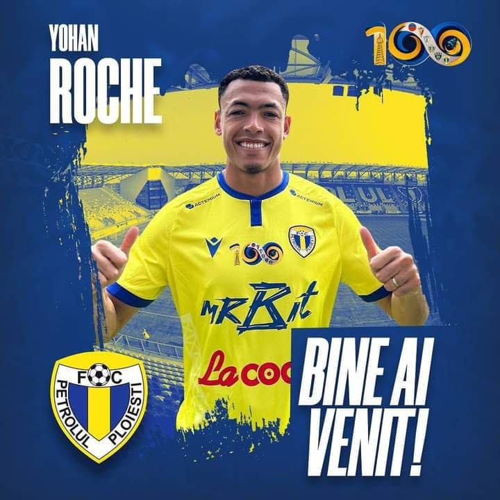 Un homme souriant en maillot jaune de football fait un geste de bienvenue devant un fond bleu et jaune avec textes et logos autour