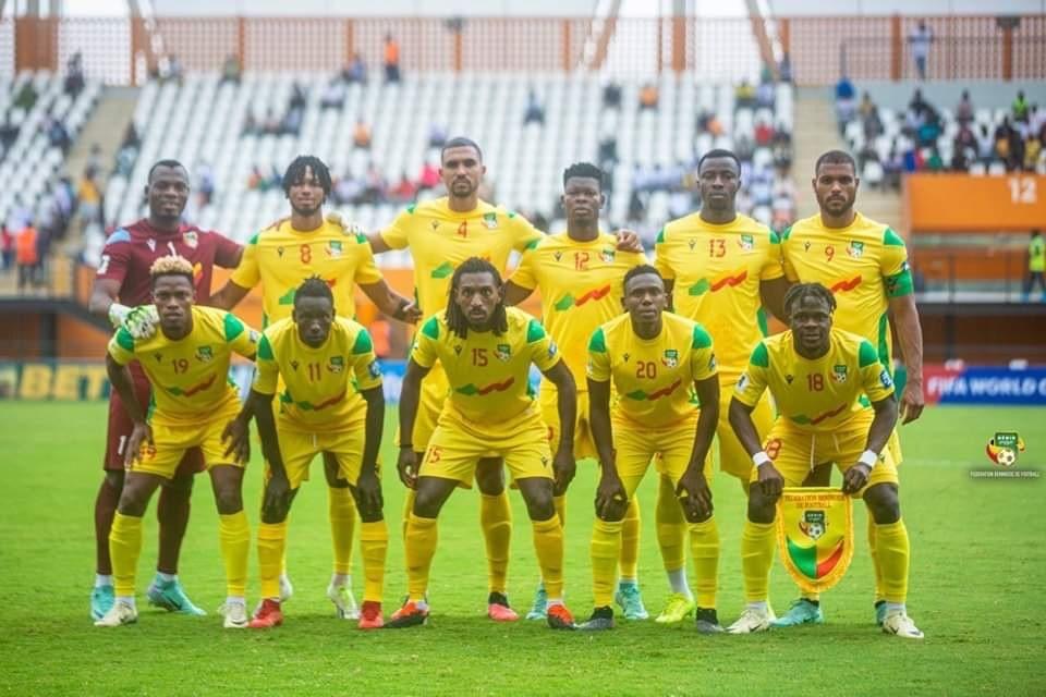 Onze joueurs de football en tenue jaune posent sur un terrain vide de stade pour une photo d'équipe