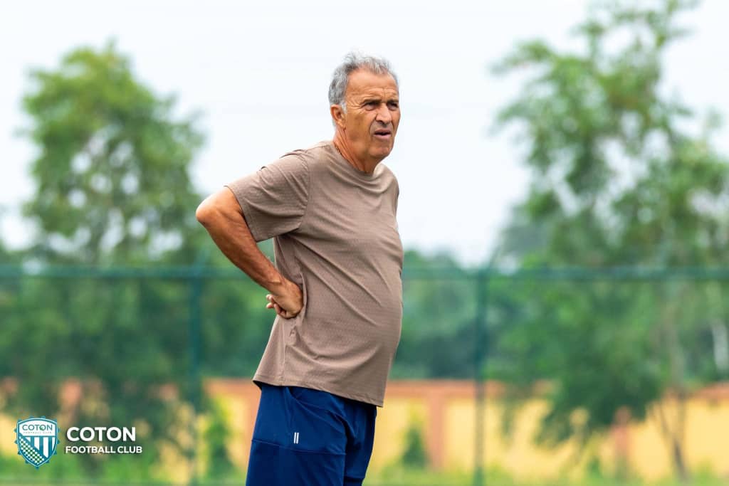 Homme d’âge mûr en tenue sportive debout les mains sur les hanches sur un terrain de sport en plein air