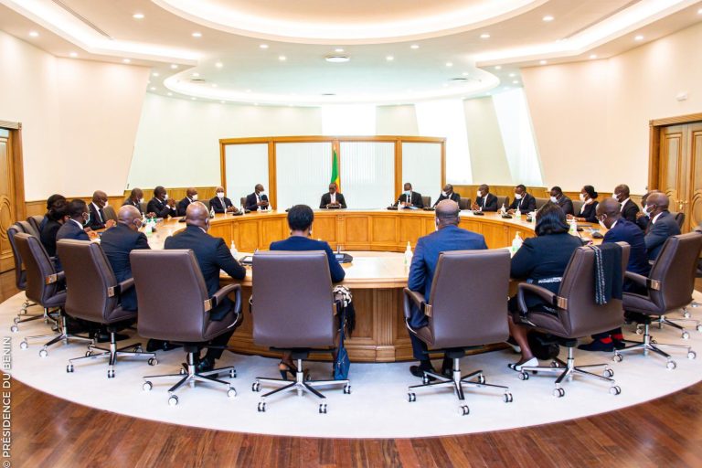Un groupe de personnes assises autour d'une grande table ronde dans une salle de réunion lumineuse et moderne