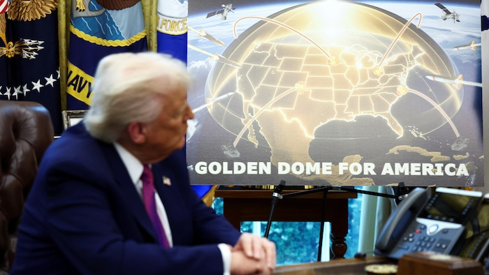 Un homme en costume regarde une grande affiche avec une carte des États-Unis surmontée d'un dôme doré et des lignes de connexion aériennes.