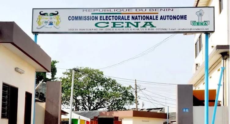 Panneau suspendu indiquant la Commission Électorale Nationale Autonome, bâtiment et arbres en arrière-plan