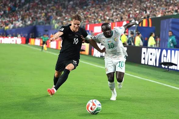 Deux joueurs de football en pleine course vers le ballon sur un terrain lors d’un match très disputé