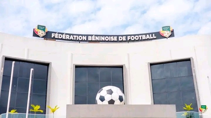 Façade blanche d un bâtiment avec un grand ballon de football noir et blanc et une inscription Fédération Béninoise de Football